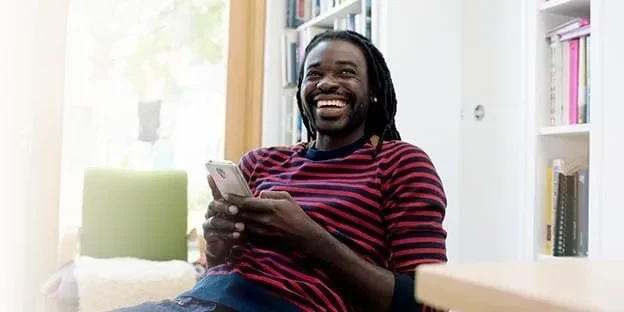 Man holding mobile laughing